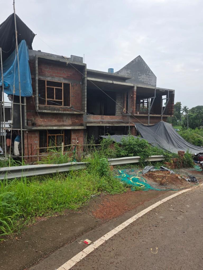 Building under construction with laterite brickwork and tarps